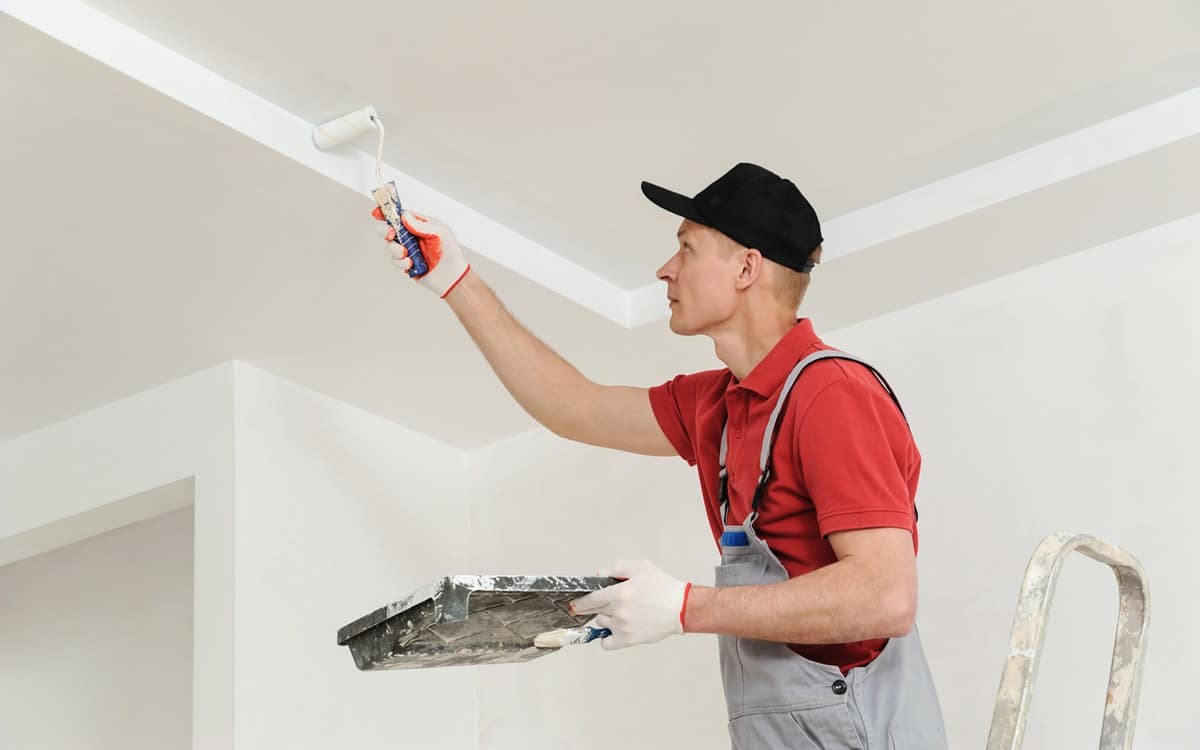Painting the ceiling and walls. expert painter applying pain efficiently