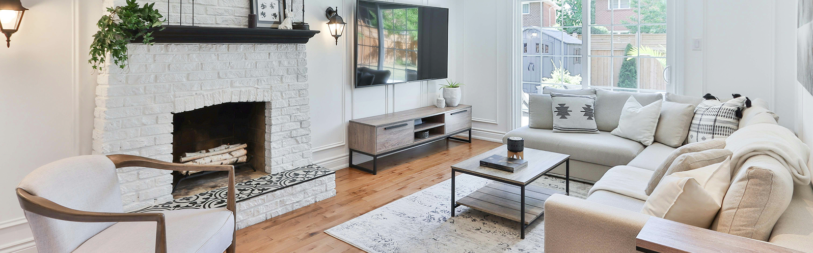 Modern living room with a cozy fireplace, stylish furniture, and large windows, showcasing a blend of comfort and contemporary design, reflecting Queen City Painting's commitment to quality home aesthetics.
